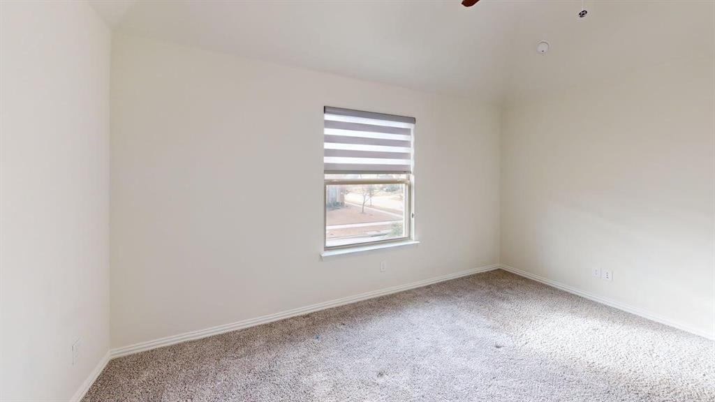 Vaulted ceiling, wall-to-wall carpeting, and window with light-filtering roller shades