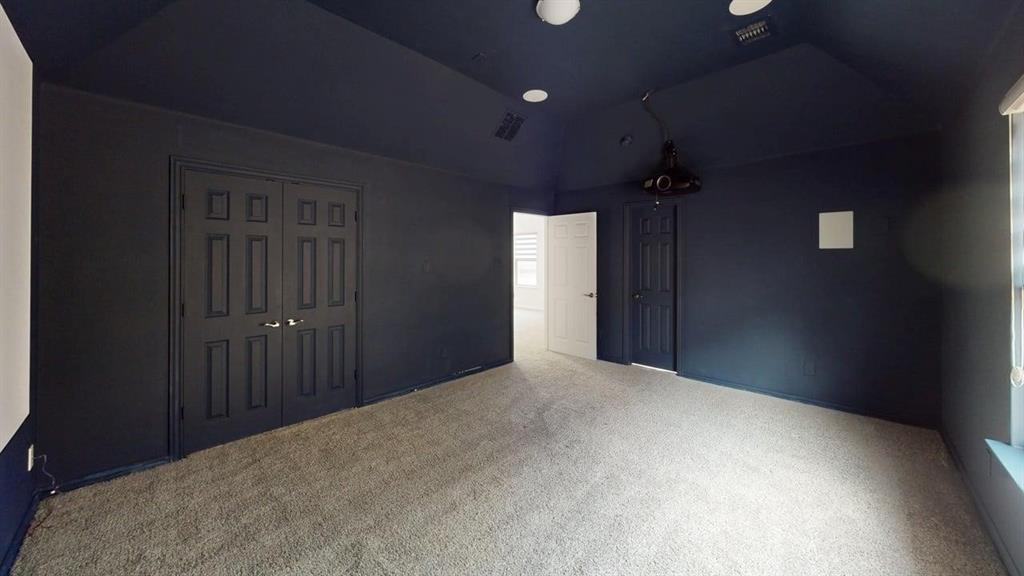 Vaulted ceiling with recessed lighting, neutral carpeting, and double-door storage