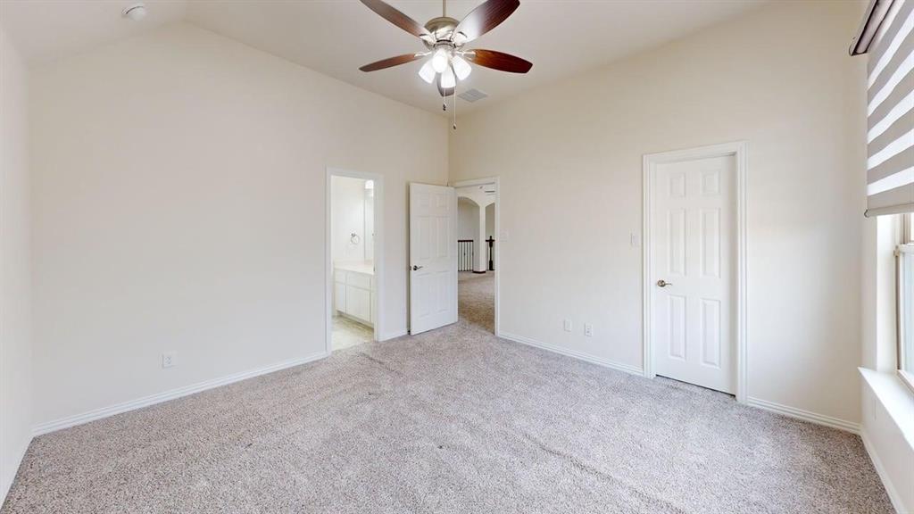 Vaulted ceilings, neutral wall color, multi-blade ceiling fan with integrated lighting, wall-to-wall carpeting, and six-panel interior doors