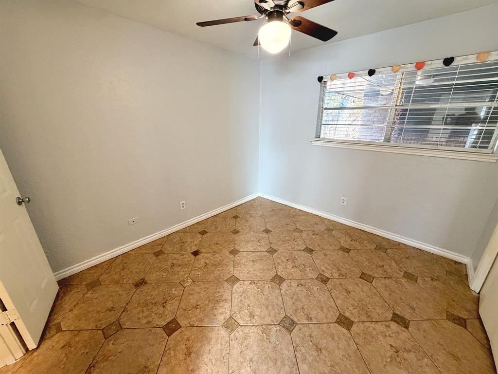Room featuring decorative tile flooring, ceiling fan with integrated light fixture, and horizontal blind window treatment