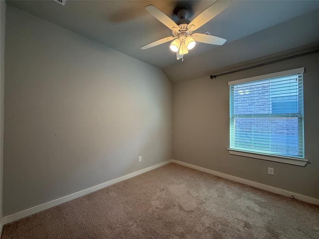 Room featuring vaulted ceilings, carpeted flooring, neutral wall paint, a multi-blade ceiling fan with integrated lighting, and a window with horizontal blinds