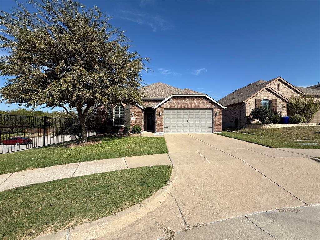 Brick exterior featuring a gabled roofline, front-facing two-car garage, concrete driveway, and mature landscaping Brick exterior featuring a gabled roofline, front-facing two-car garage, concrete driveway, and mature landscaping