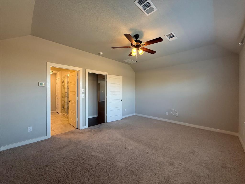Room featuring vaulted ceilings, neutral carpeting, and a multi-light ceiling fan
