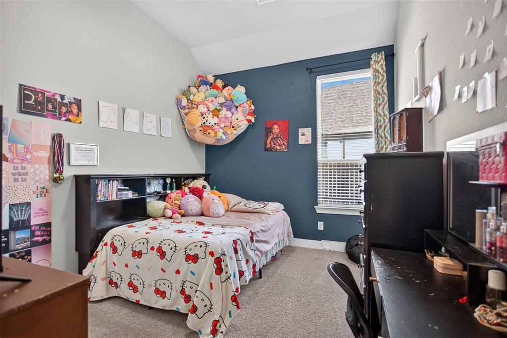 Vaulted ceilings, carpeted flooring, and a window with neutral-toned blinds