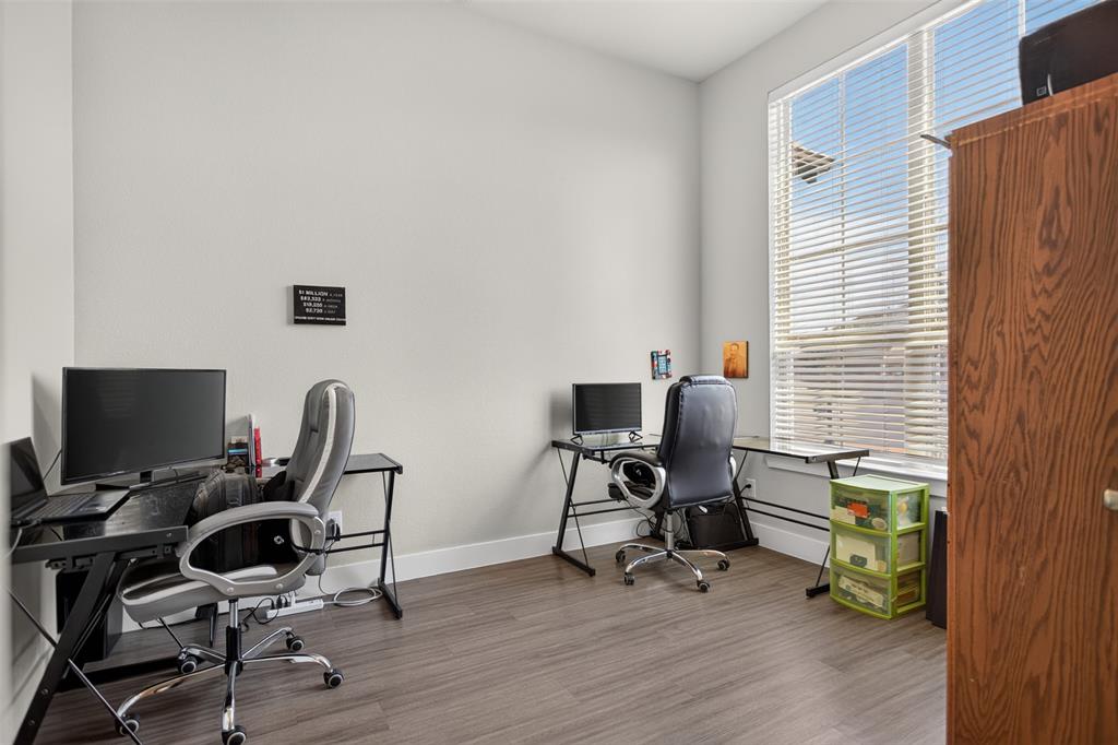 Wood-finish flooring and a large window with horizontal blinds