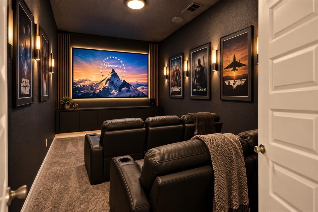 Dedicated media room featuring a built-in entertainment console, wall-mounted light fixtures, screen backlighting, and vertical wood paneling accents