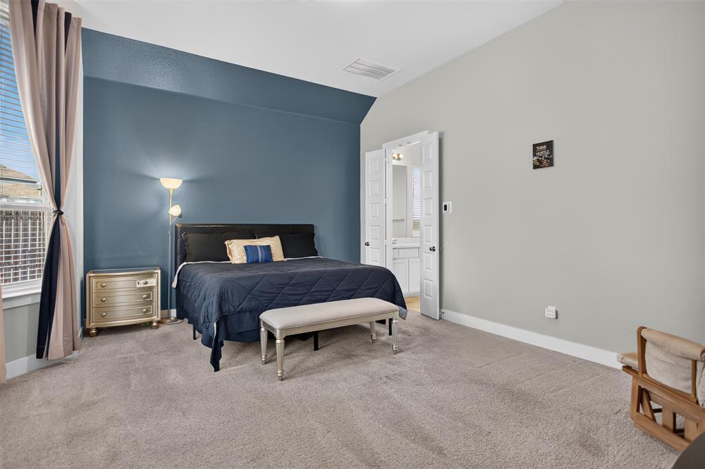 Spacious room featuring neutral carpeting, a dual-tone wall treatment with a bold accent wall, double-door entry, and window with tiered drapery