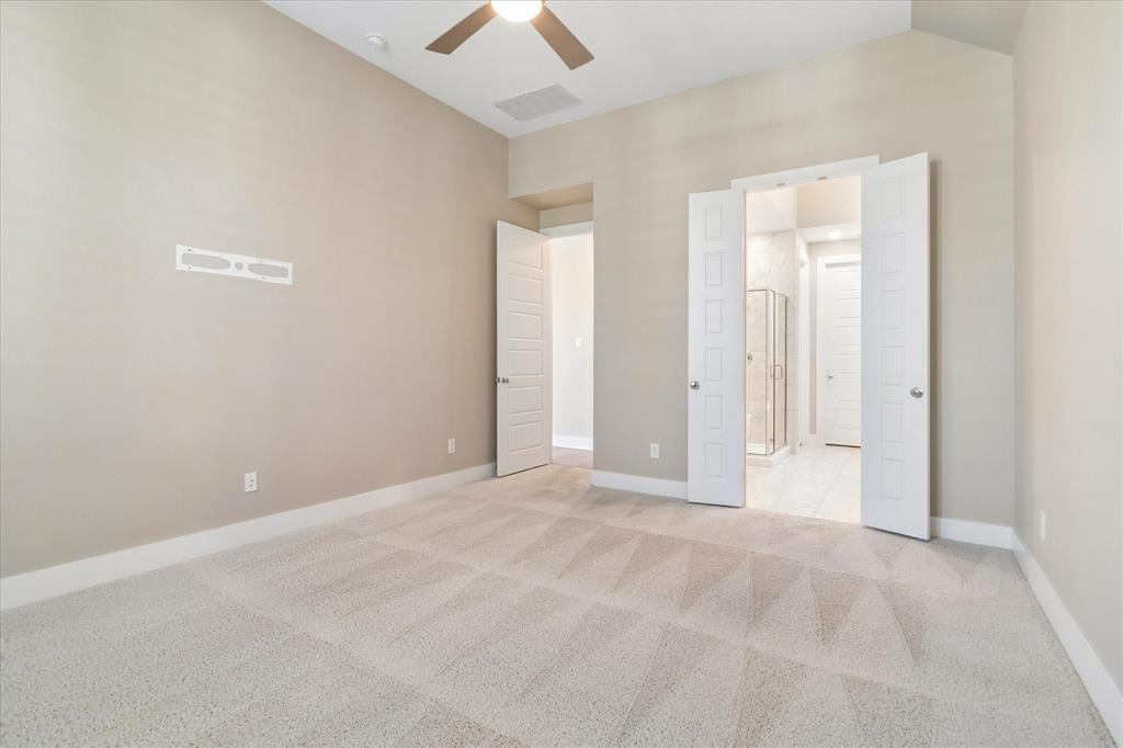 Neutral-toned room featuring high vaulted ceilings, wall-to-wall carpeting, a ceiling fan with integrated lighting, and white paneled doors