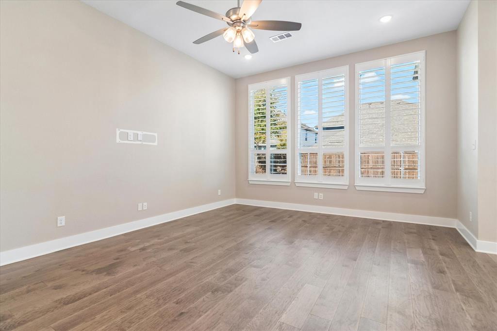 Interior space featuring wood-finish flooring, plantation shutters, recessed lighting, and a multi-blade ceiling fan