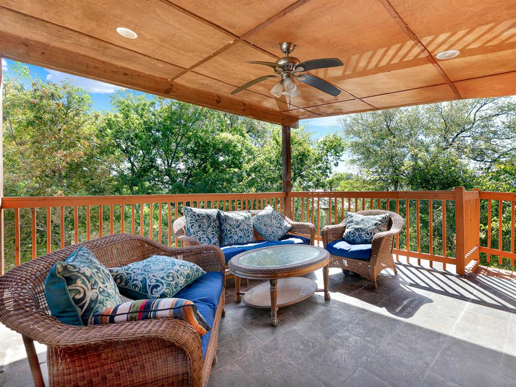 Covered balcony featuring a wood-paneled ceiling, recessed lighting, a ceiling fan, tiled flooring, and wooden railings