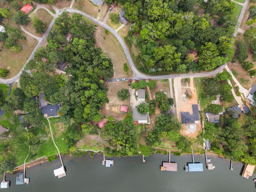 Waterfront lot featuring mature tree canopy, direct shoreline access, and private deep-water dock