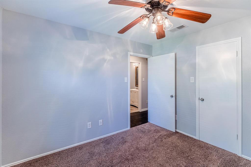 Neutral-toned walls, ceiling fan with integrated multi-light fixture, and neutral carpeting