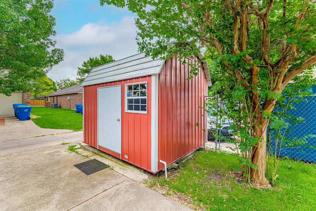 Metal storage structure featuring a barn-style roof, single-door entry, and a side window