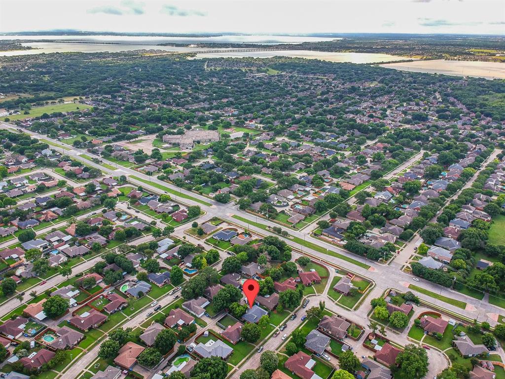 Aerial perspective of a residential lot situated within a suburban neighborhood featuring mature trees and proximity to regional waterways