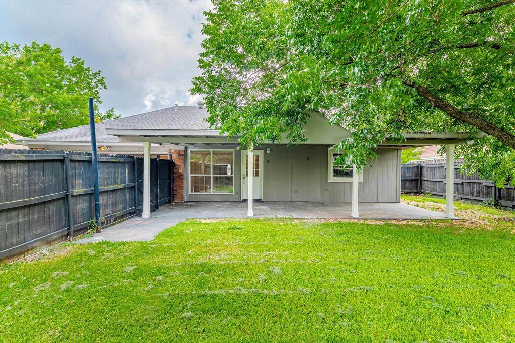 Covered patio with concrete flooring, fenced backyard, and mature shade trees