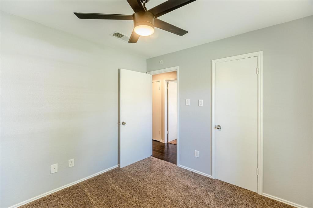 Neutral-toned walls, high-pile carpeting, and a ceiling fan with integrated lighting