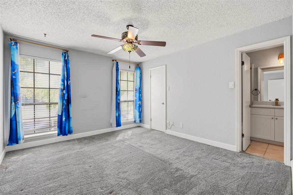 Room featuring grey carpeting, two multi-pane windows, and a ceiling-mounted fan with integrated lighting