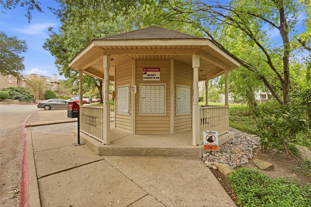 Octagonal outdoor pavilion featuring wood-finish siding, a covered walkway, and built-in mail compartments