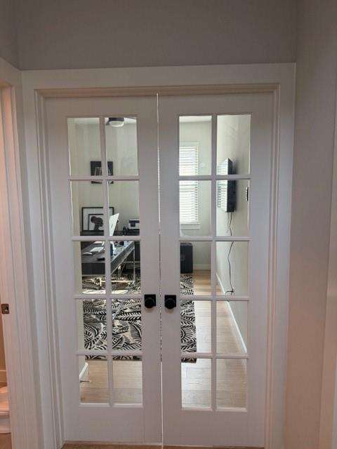 White French doors featuring a ten-pane glass design and matte black hardware White French doors featuring a ten-pane glass design and matte black hardware