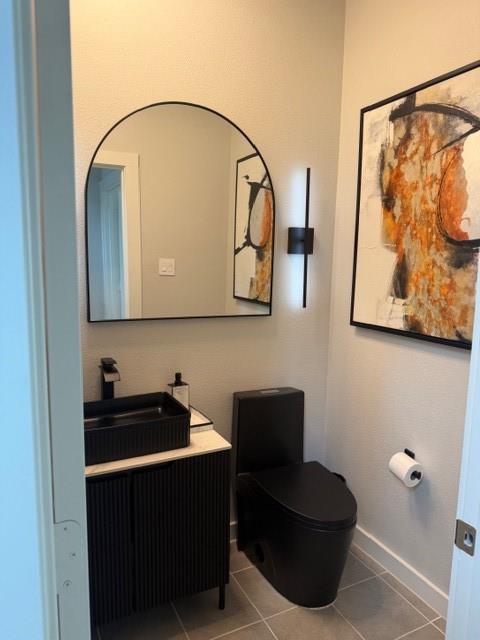 Modern vanity with a rectangular sink, matte black faucet, arched wall mirror, vertical sconce lighting, and a black toilet Modern vanity with a rectangular sink, matte black faucet, arched wall mirror, vertical sconce lighting, and a black toilet