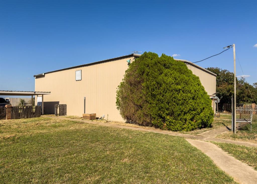 Exterior building featuring a metal-panel facade, a concrete walkway, and an attached carport