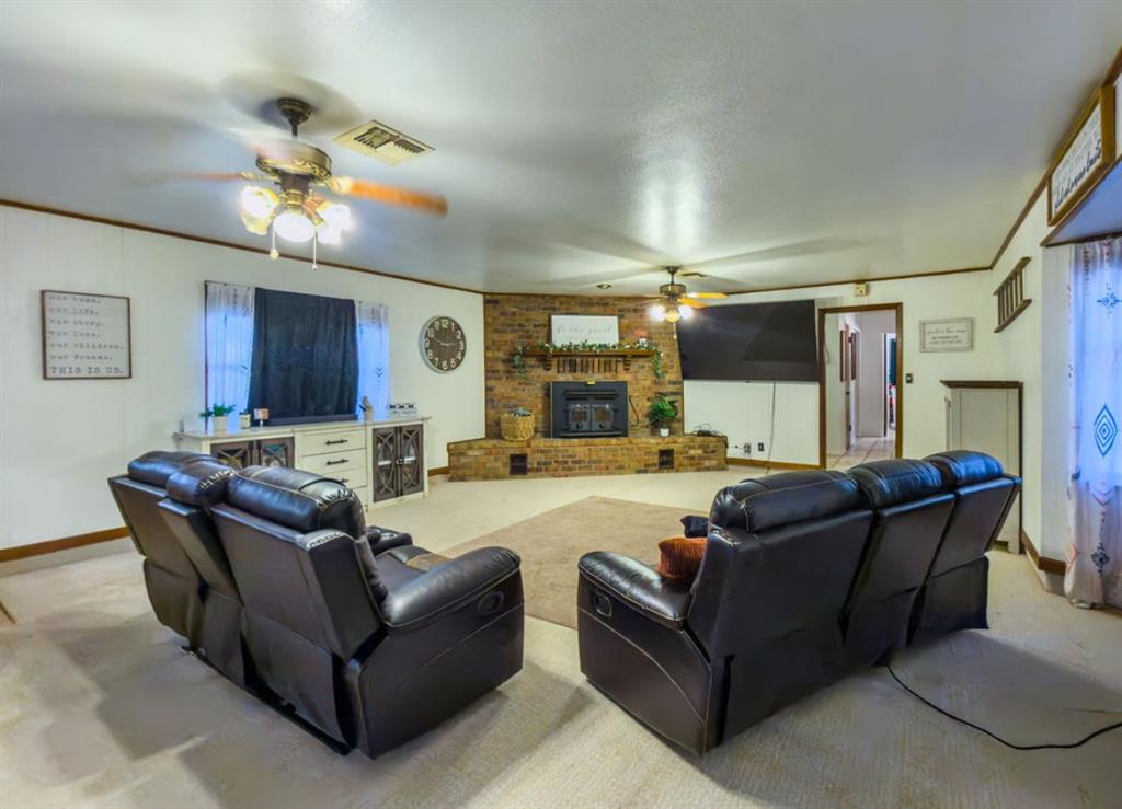Brick fireplace with an integrated mantel and a recessed hearth, dual ceiling fans, and neutral wall finishes Brick fireplace with an integrated mantel and a recessed hearth, dual ceiling fans, and neutral wall finishes