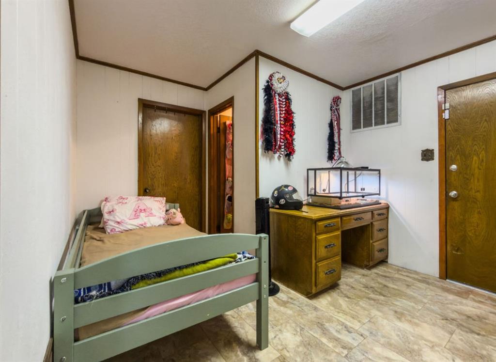 Paneled wall surfaces with wood-finish trim, tile flooring, and solid-core wooden doors