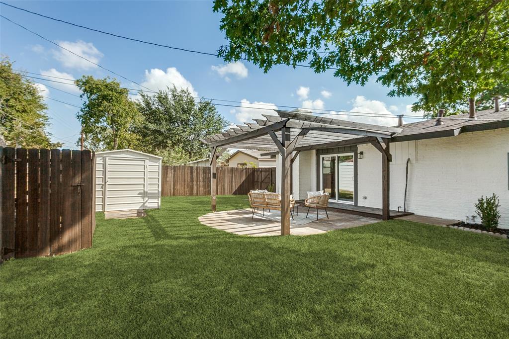 Backyard featuring a wood pergola, paver patio, metal storage shed, and wood perimeter fencing