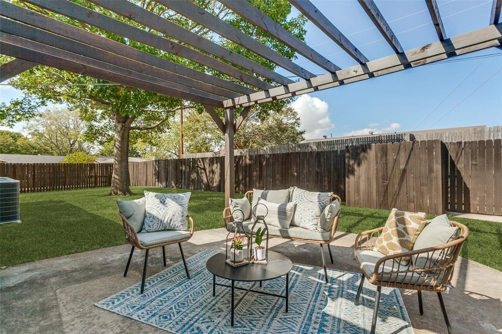 Backyard featuring a concrete patio, a wooden pergola, a manicured lawn, and perimeter wood fencing
