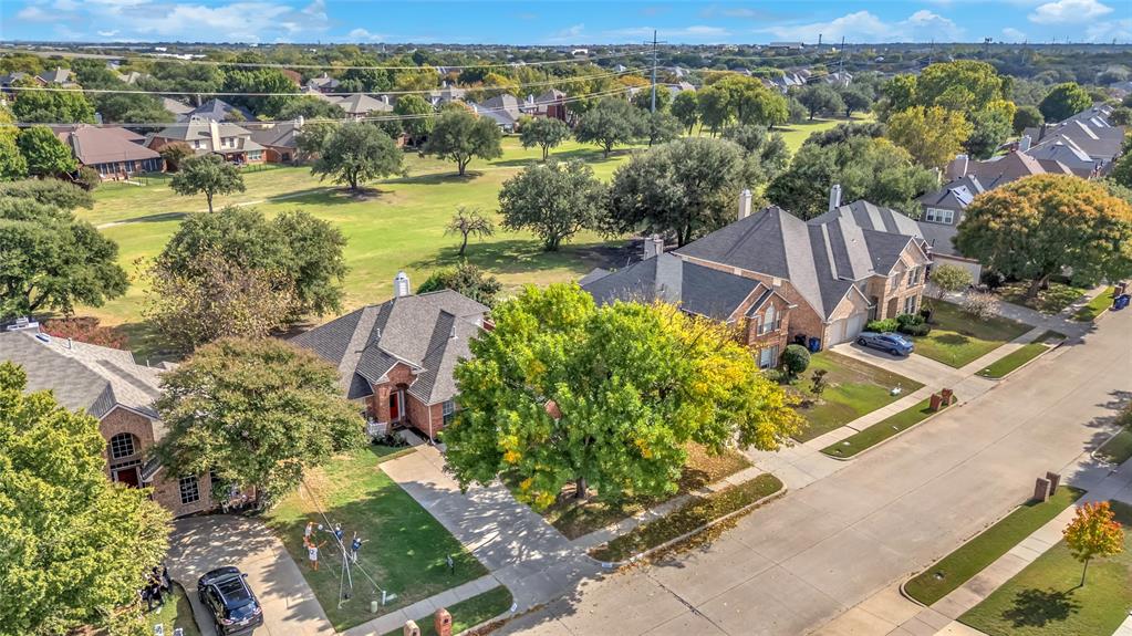 Aerial view of the home backing to the fairway with mature trees — 5804 Lafayette Dr, Frisco