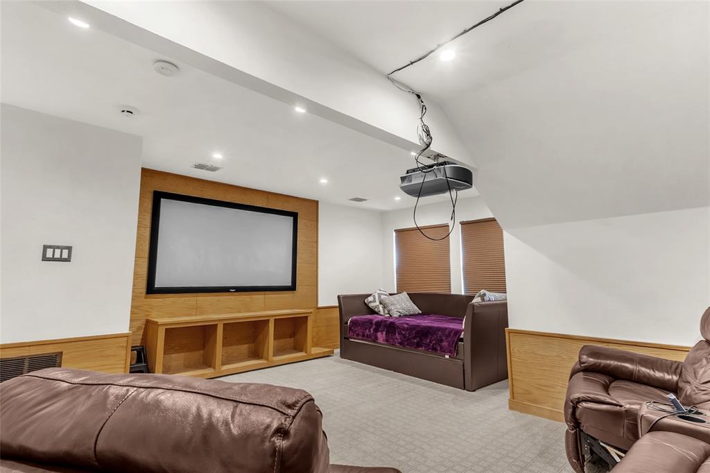 Upstairs media room with wood accent wall, wainscot, and recessed lights — 5804 Lafayette Dr, Frisco