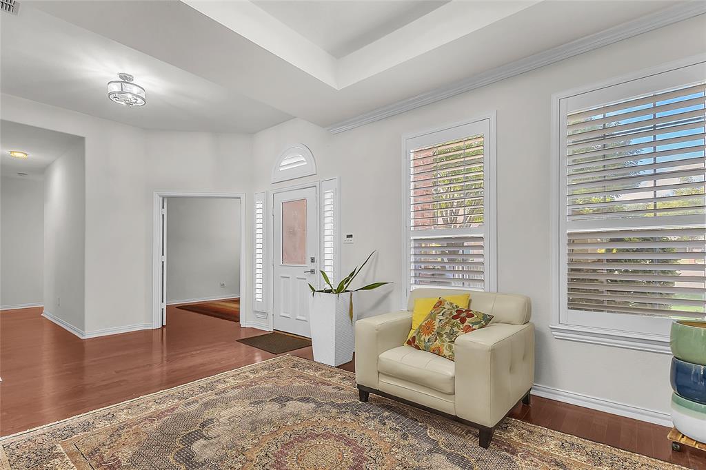 Entry and front room with tray ceiling and engineered hardwood floors — 5804 Lafayette Dr, Frisco