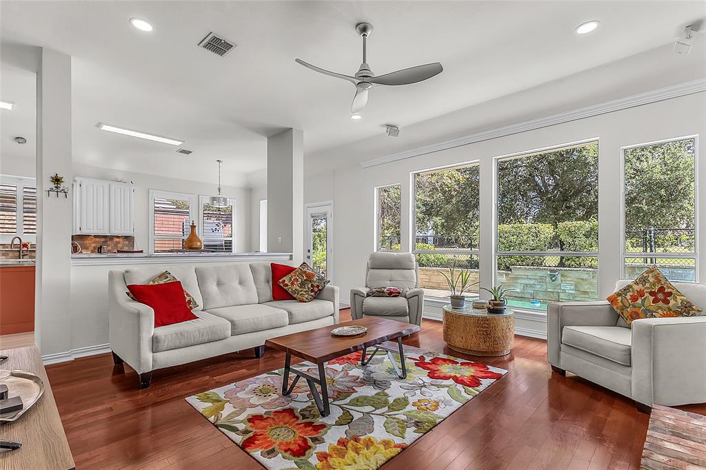 Open living room with wall of windows to pool and golf course trees — 5804 Lafayette Dr, Frisco