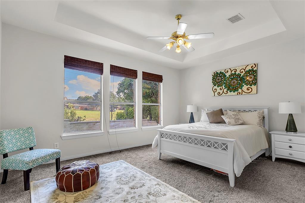 Primary bedroom with three windows overlooking golf course greenery — 5804 Lafayette Dr, Frisco