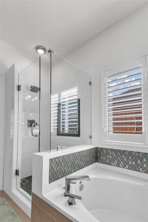 Primary bath with frameless glass shower, rain head, and soaking tub — 5804 Lafayette Dr, Frisco