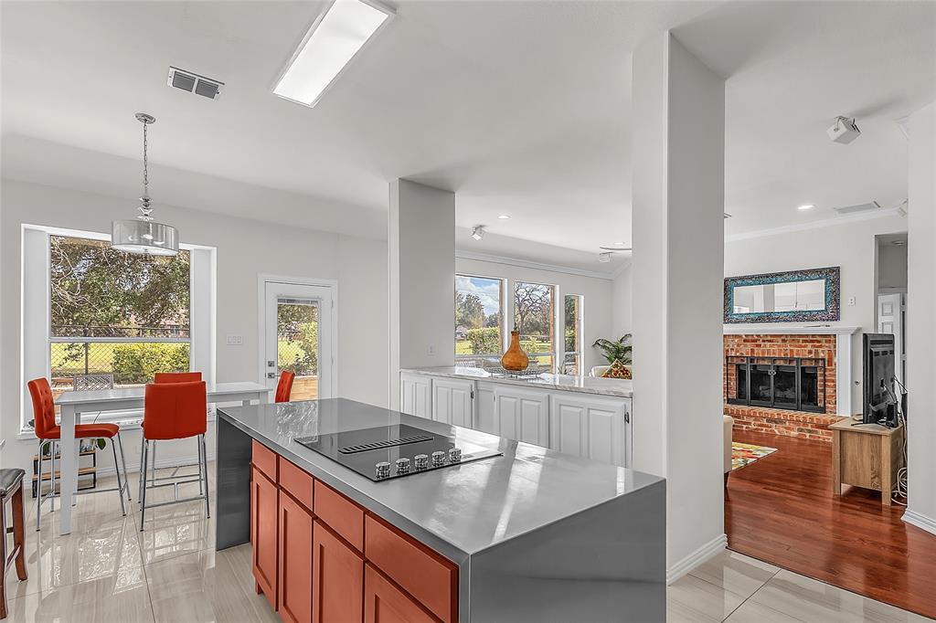 Kitchen island view to breakfast nook, living room, and fireplace — 5804 Lafayette Dr, Frisco