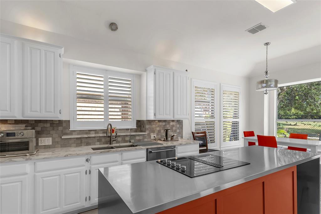 Kitchen sink wall with tile backsplash and plantation shutters — 5804 Lafayette Dr, Frisco