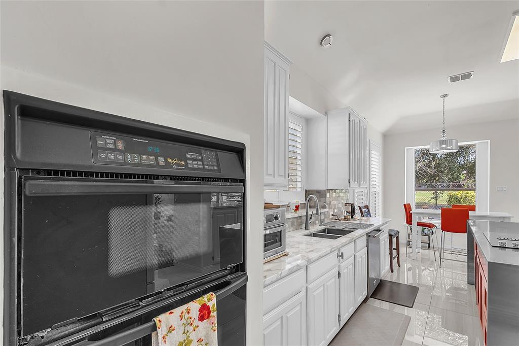 Kitchen with double wall oven, granite counters, and tile floors — 5804 Lafayette Dr, Frisco