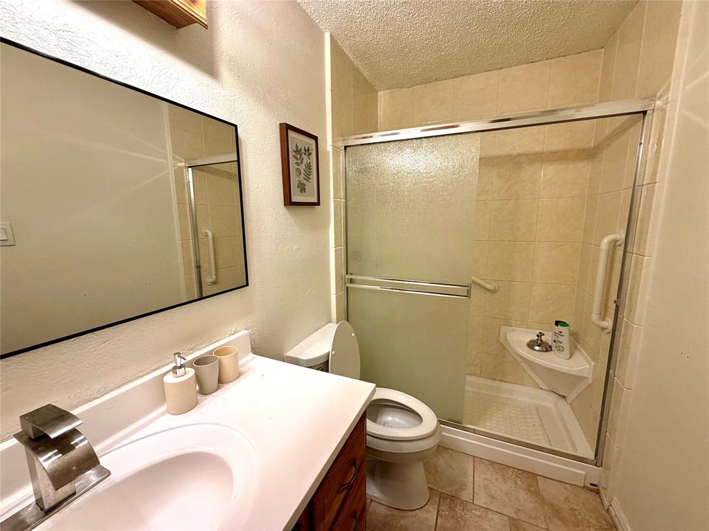 Bathroom featuring a shower with sliding frosted glass doors, a white shower pan, and a corner shelf