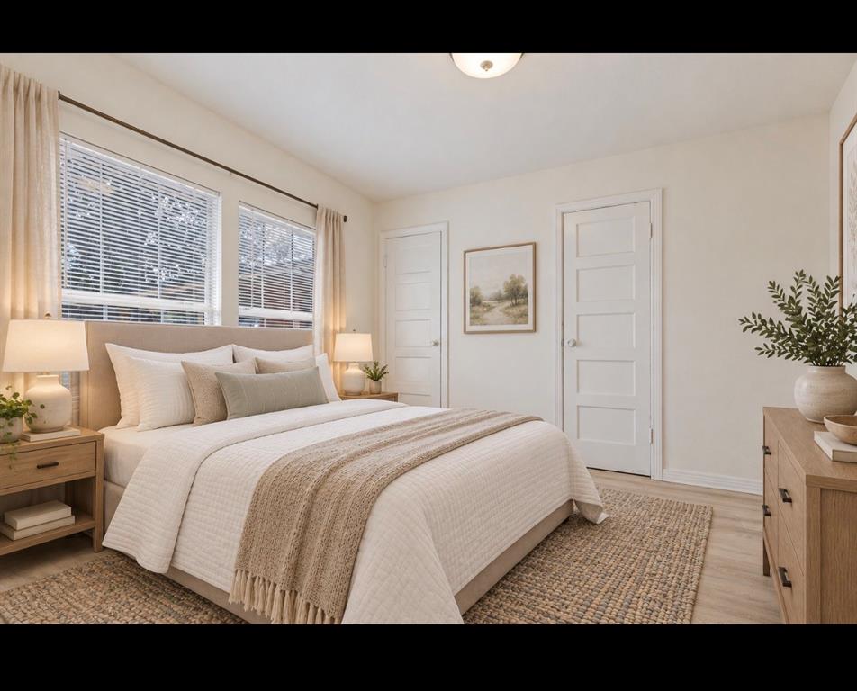 Neutral-toned room featuring light wood-finish flooring, dual windows with horizontal blinds, and two-panel interior doors *virtually staged*