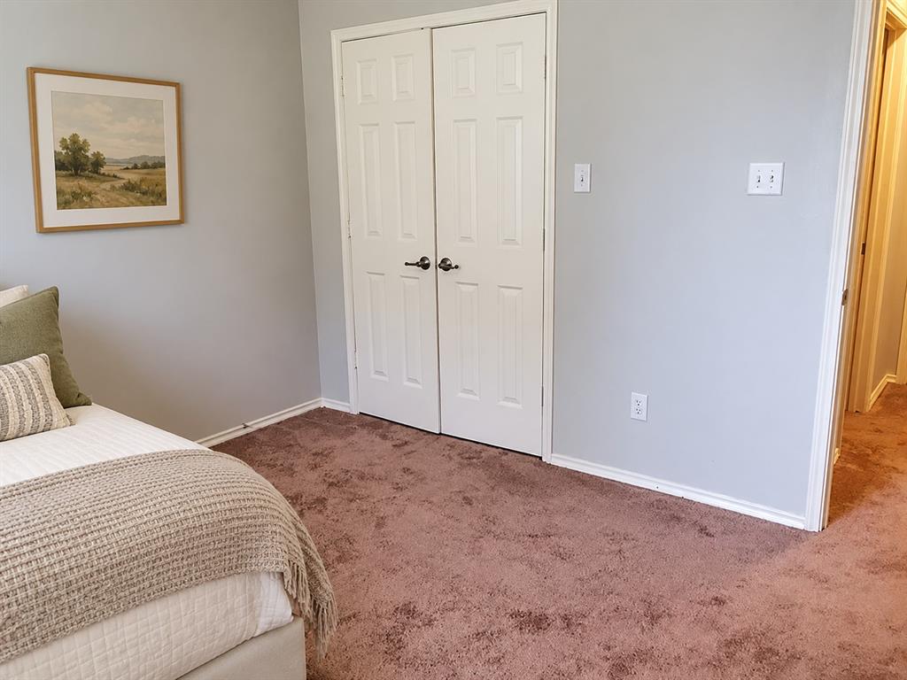 Interior room featuring plush carpeting, neutral wall paint, and a double-door closet with brushed nickel hardware Interior room featuring plush carpeting, neutral wall paint, and a double-door closet with brushed nickel hardware