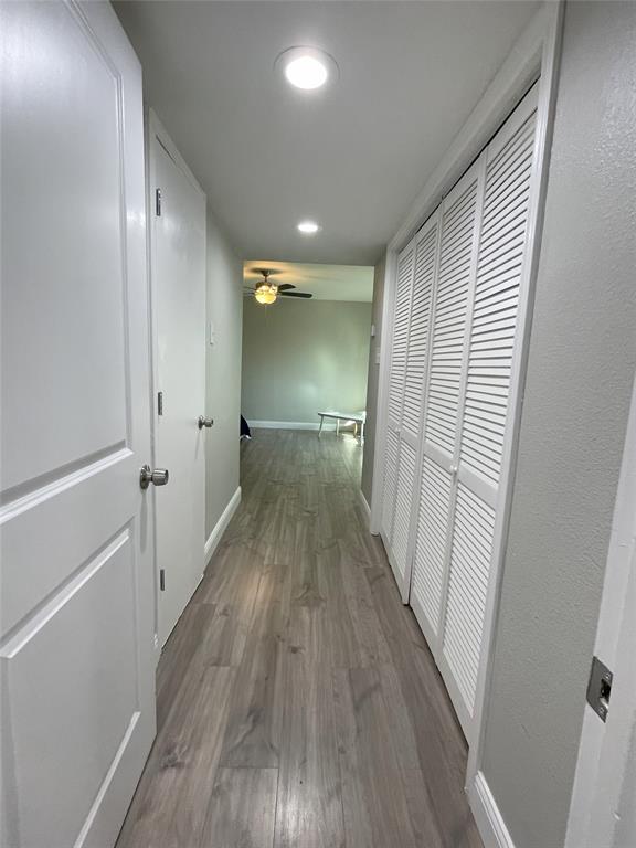 Corridor with hardwood / wood-style floors