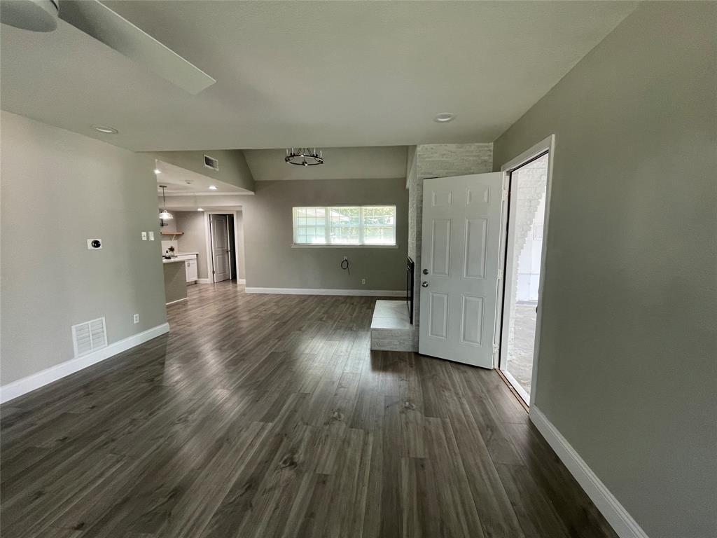 Unfurnished living room featuring dark hardwood / wood-style flooring