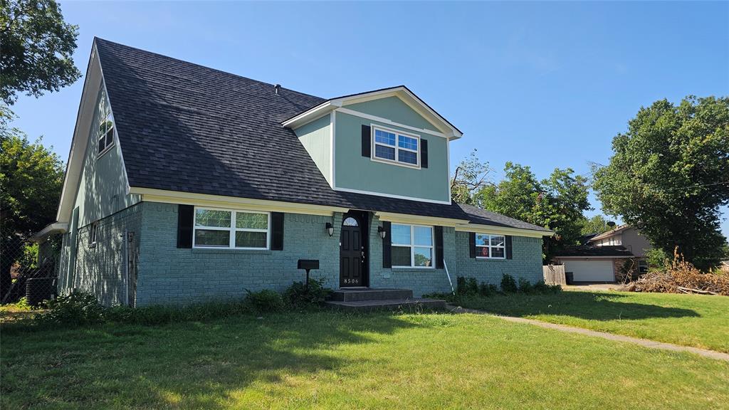 View of front of house with a garage and a front yard