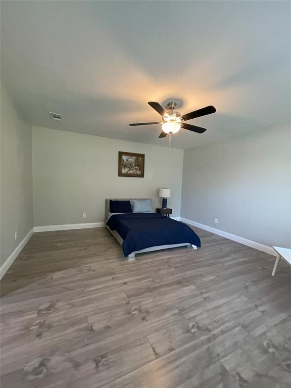 Bedroom with ceiling fan and hardwood / wood-style floors