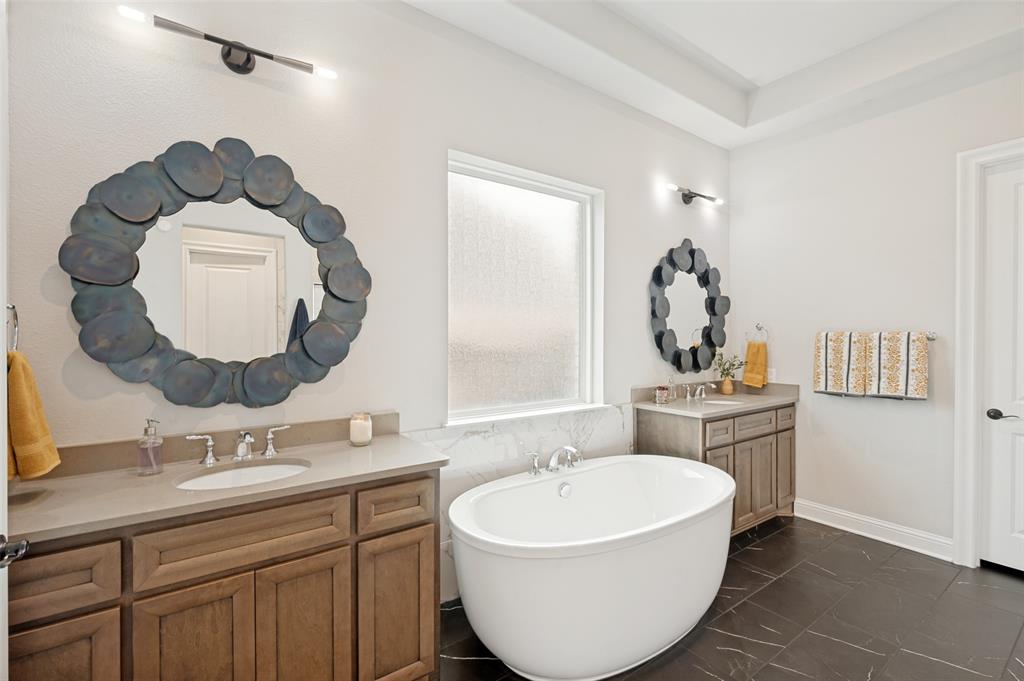 Freestanding soaking tub with dual vanity sinks in this spa-like primary ensuite.