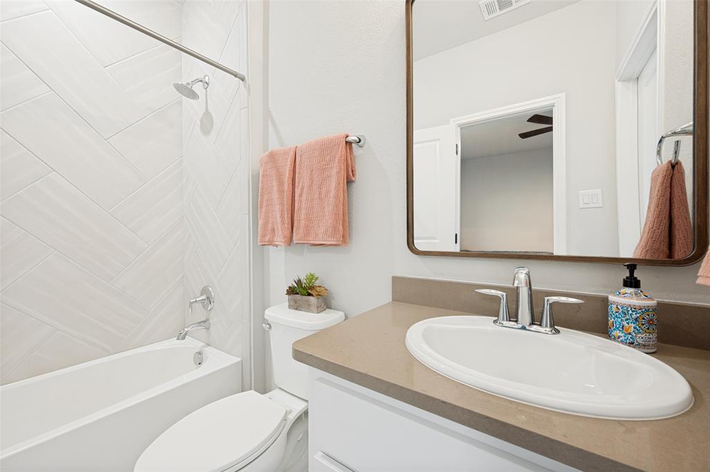 Bathroom featuring a single vanity with an integrated sink, polished chrome faucet, and a framed mirror