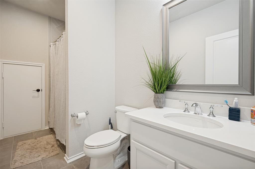 Bathroom featuring a white vanity with an integrated sink, polished chrome faucet, and a framed mirror