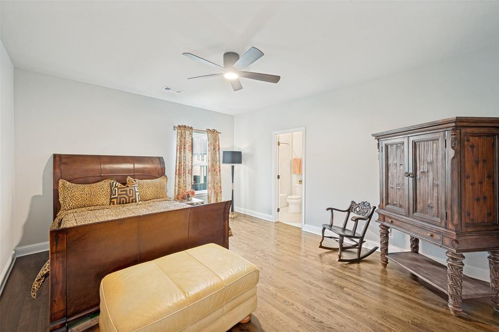 Upstairs spacious bedroom featuring wood-finish flooring, a ceiling fan with integrated lighting, and a private ensuite.