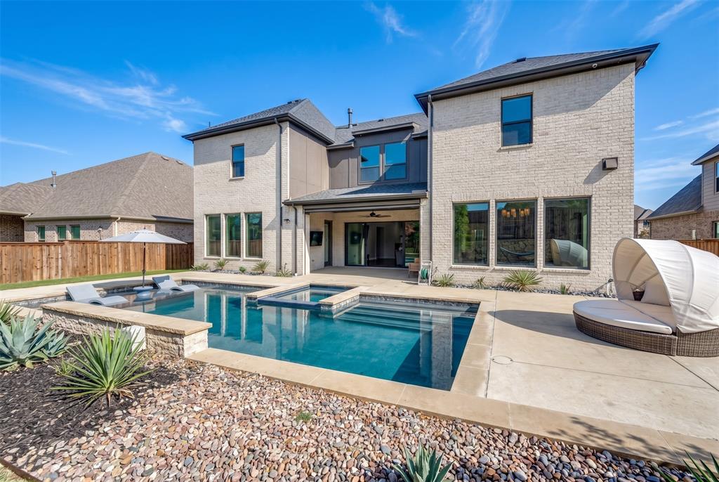 Contemporary brick exterior with a multi-level pool, integrated spa, and expansive concrete patio